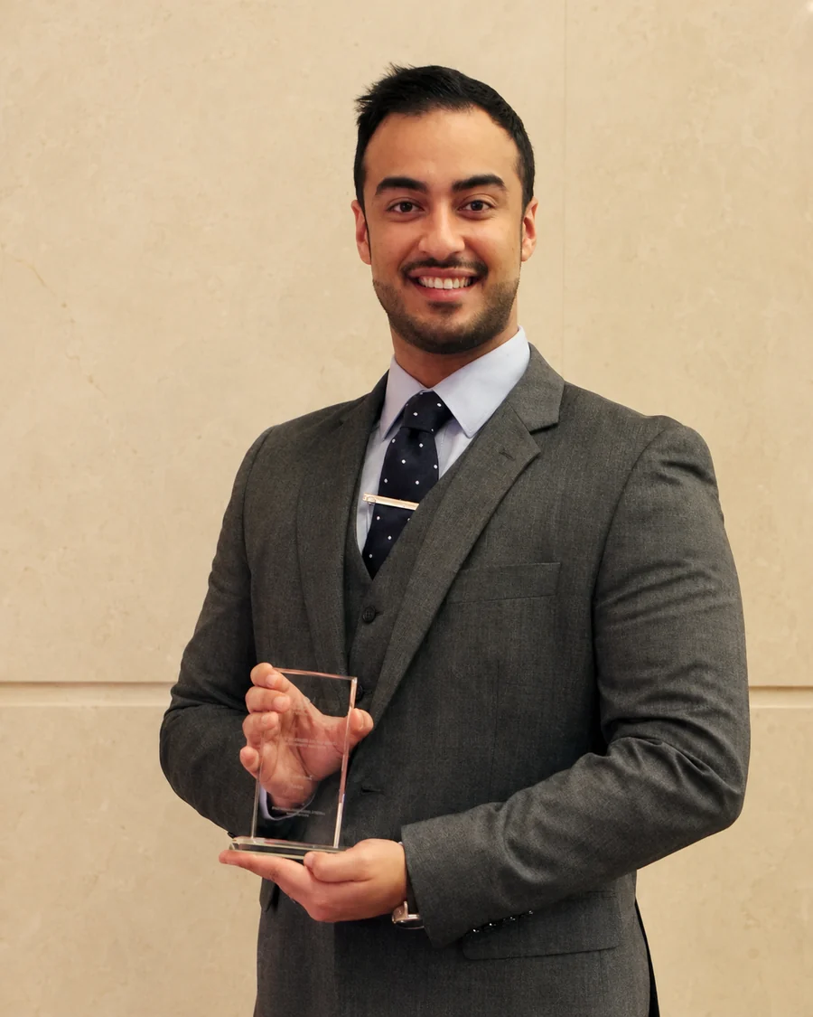 Ali Owji holding the Outstanding Economic Student award.