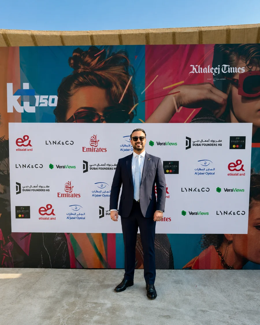 Ali Owji at the Khaleej Times KT+150 event, standing before the sponsor wall.